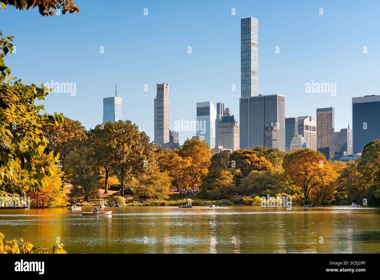 New York City après-midi d'automne à Central Park avec des gens ramant des bateaux sur le lac. Horizon de Midtown Manhattan et gratte-ciel de Billionaires Row Banque D'Images