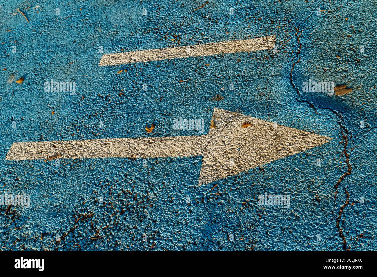 Flèche blanche sur Cracked Blue Concrete Street Banque D'Images