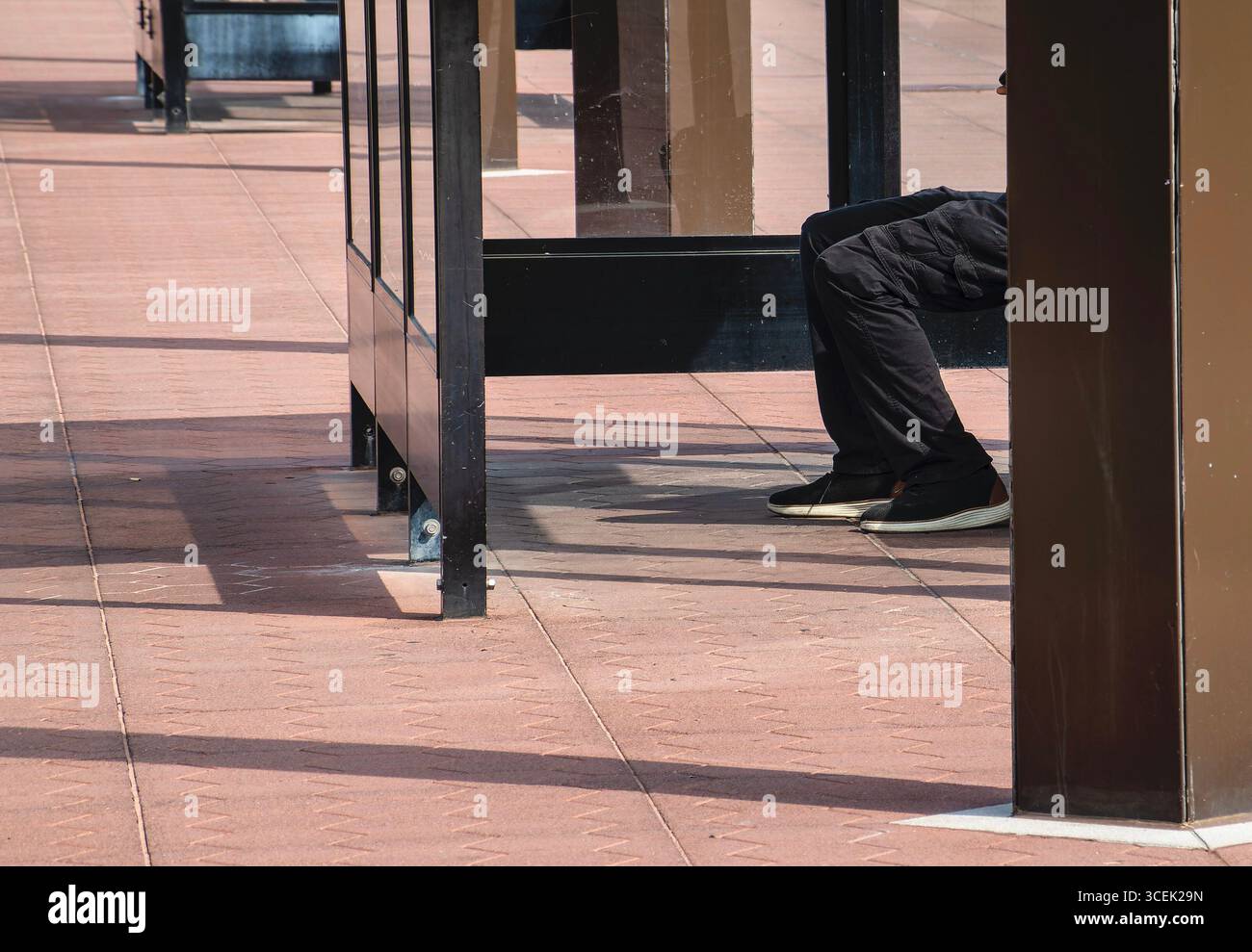 Un passager attendant dans un abri ferroviaire Banque D'Images