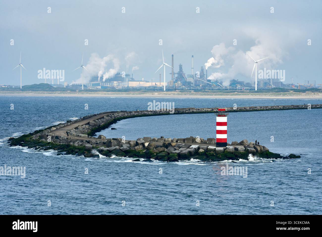 Entrée du port avec brise-vague et phare et raffineries de pétrole en arrière-plan à Ilmuiden, Amsterdam, pays-Bas Banque D'Images