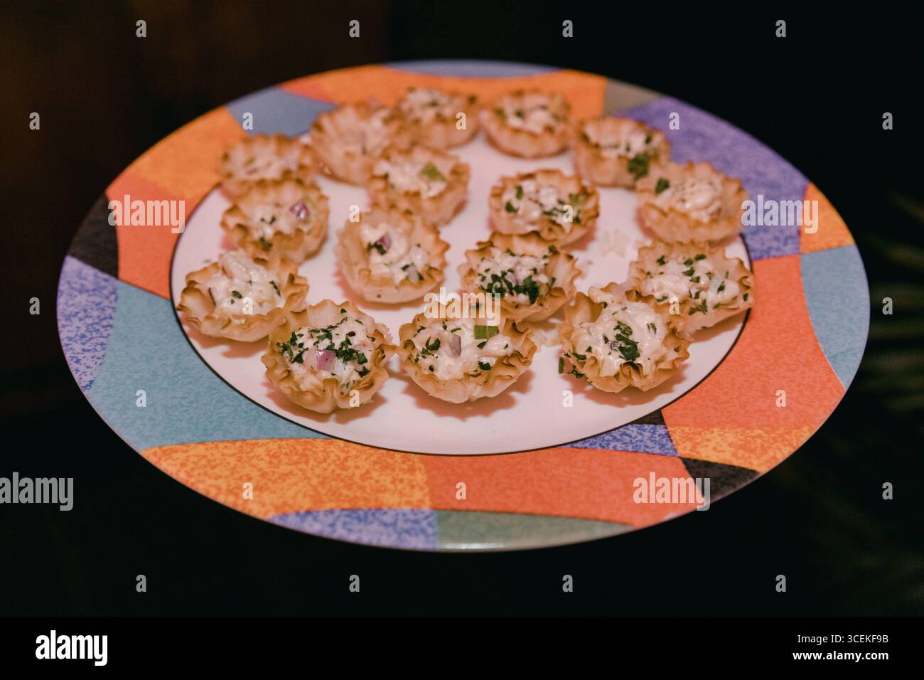 Un plateau de hors-d'œuvre de la taille d'une bouchée garni d'herbes est présenté lors d'un événement social au cours de la soirée. Banque D'Images