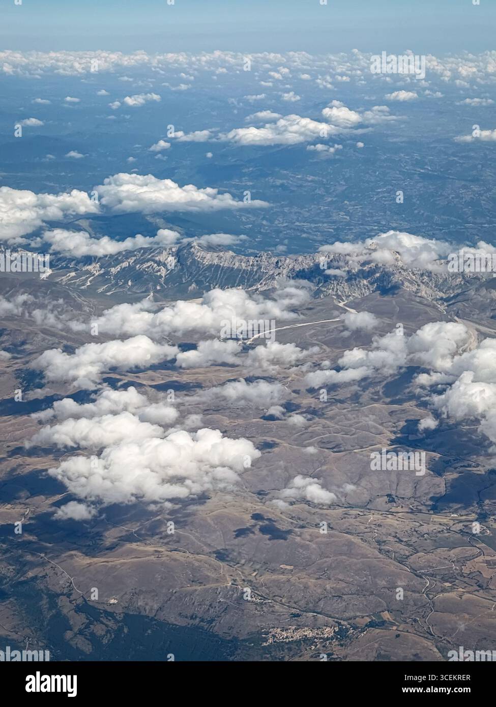 Vue aérienne de haute altitude montre un paysage accidenté et montagneux parsemé de parcelles de petits villages et de routes serpentant à travers les vallées. Fluf Banque D'Images