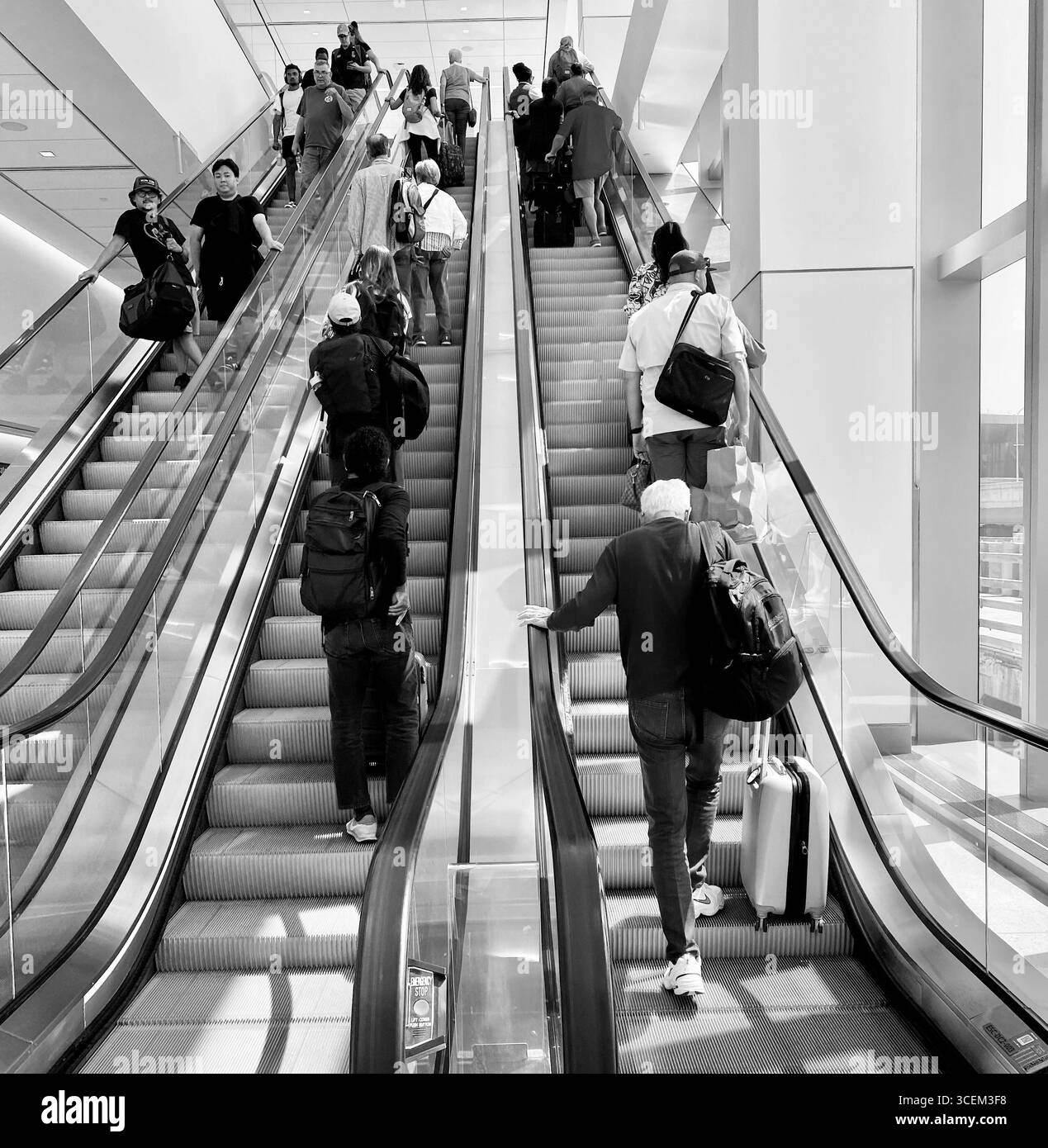 Escalator à l'aéroport de Laguardia, New York, 2025, monter avec beaucoup de gens. Banque D'Images