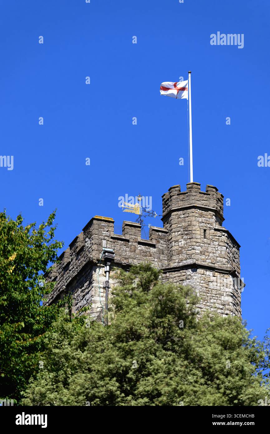 Le drapeau de l'Angleterre flottant sur la tour de l'église St Marys, Twickenham, Londres contre un ciel bleu clair. Banque D'Images
