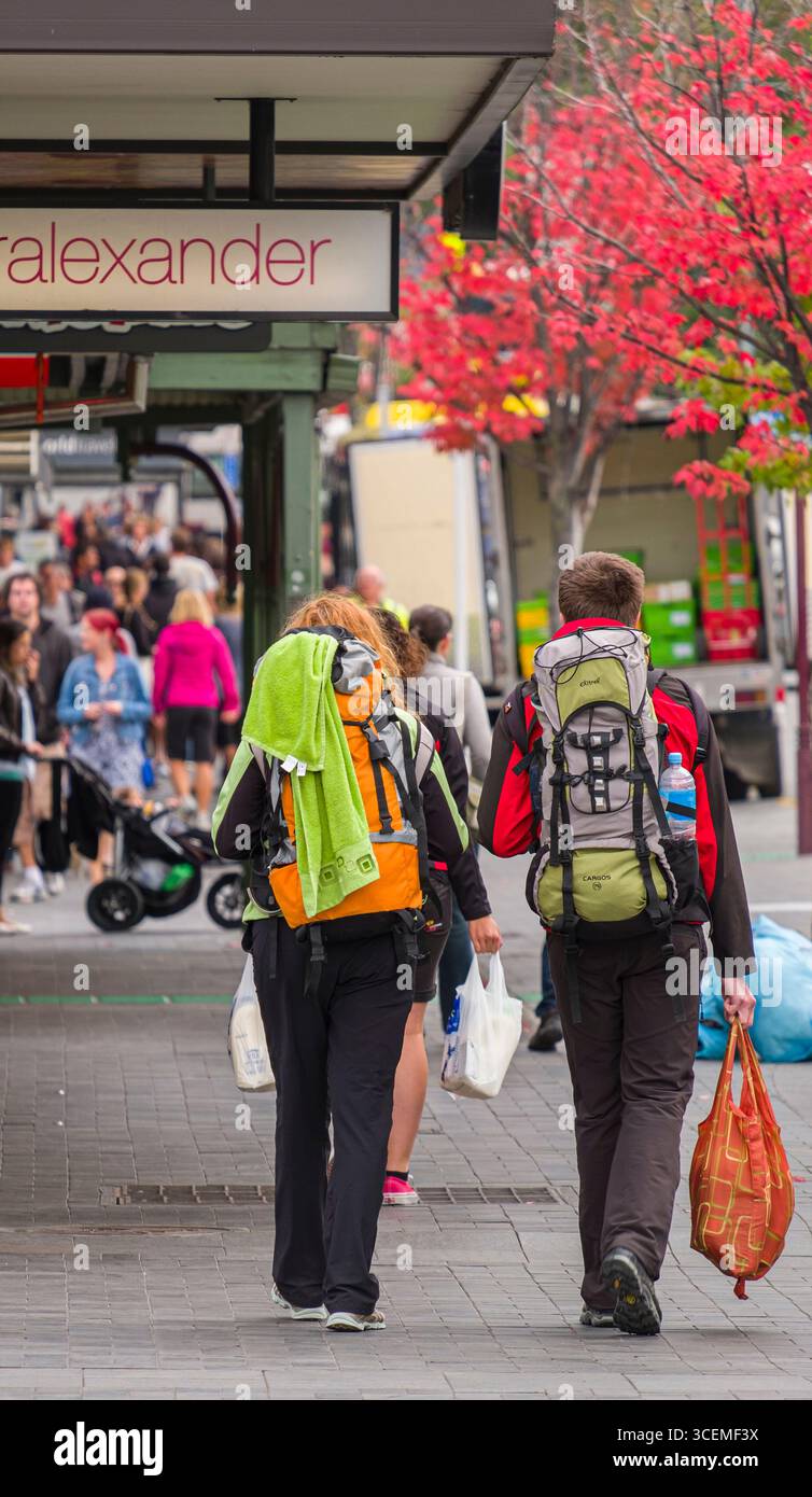 L'homme et la femme backpackers walking on sidewalk, Camp Street, Queenstown, Otago, île du Sud, Nouvelle-Zélande Banque D'Images