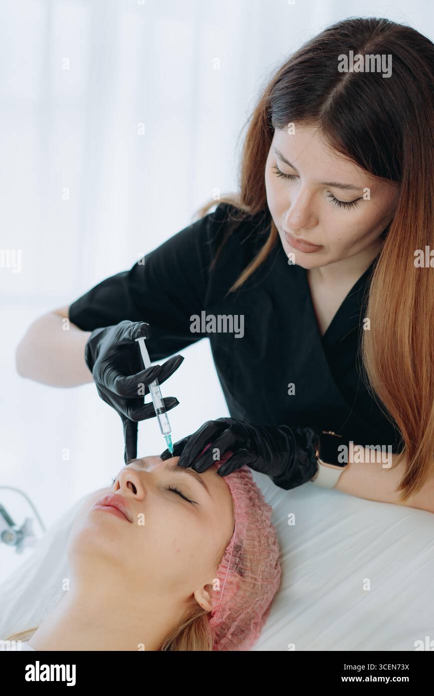 gros plan des mains professionnelles faisant une injection de rajeunissement dans la ligne sournoise de la femme Banque D'Images