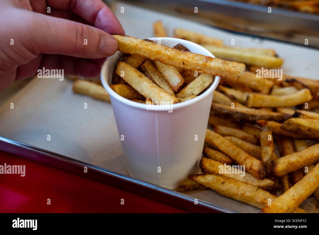 croustilles végétaliennes ou frites dans une tasse en papier et sur un plateau dans un fast food Banque D'Images