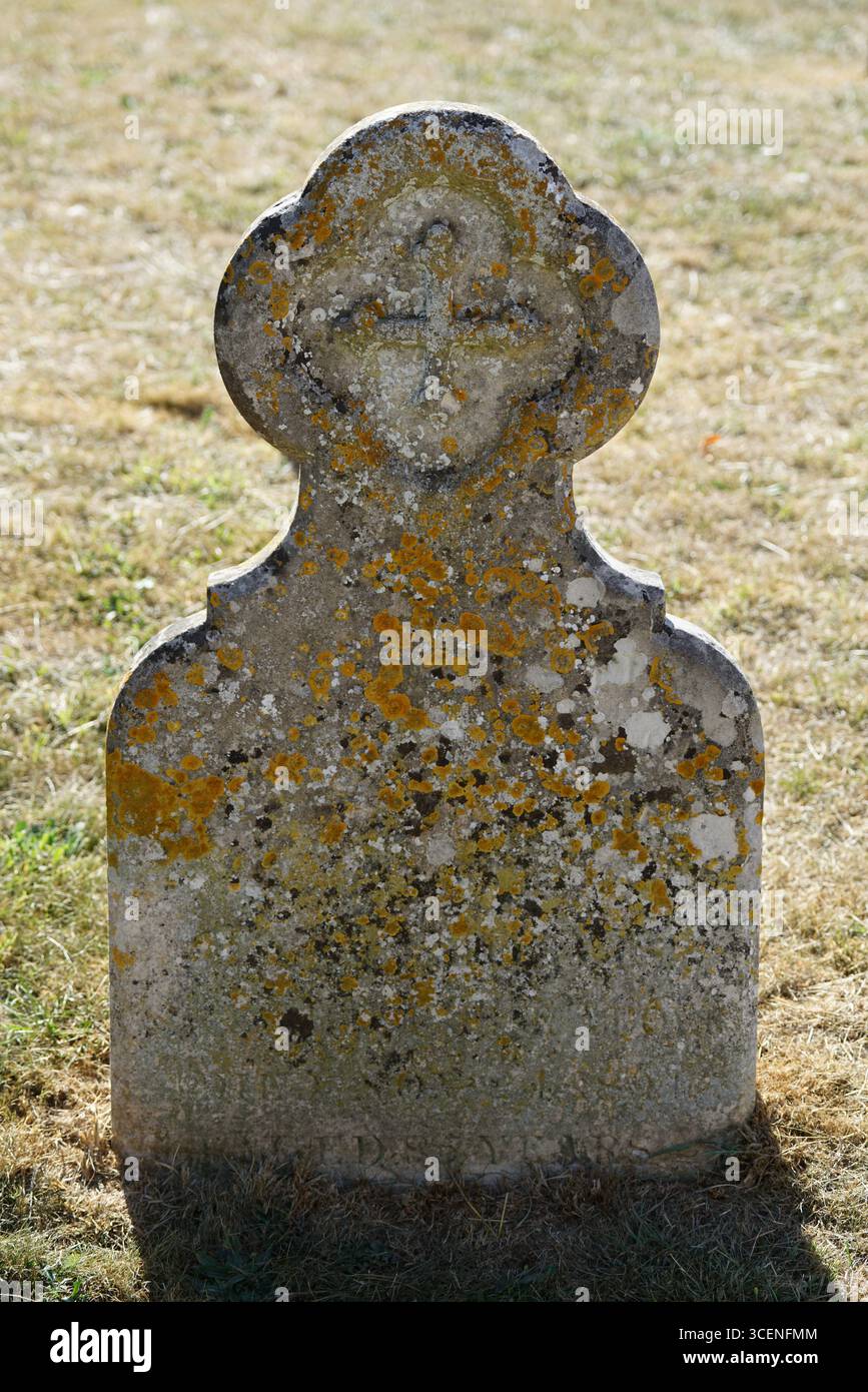 Pierre tombale en pierre altérée avec mousse dans le cimetière paisible. Adderbury, Angleterre Banque D'Images