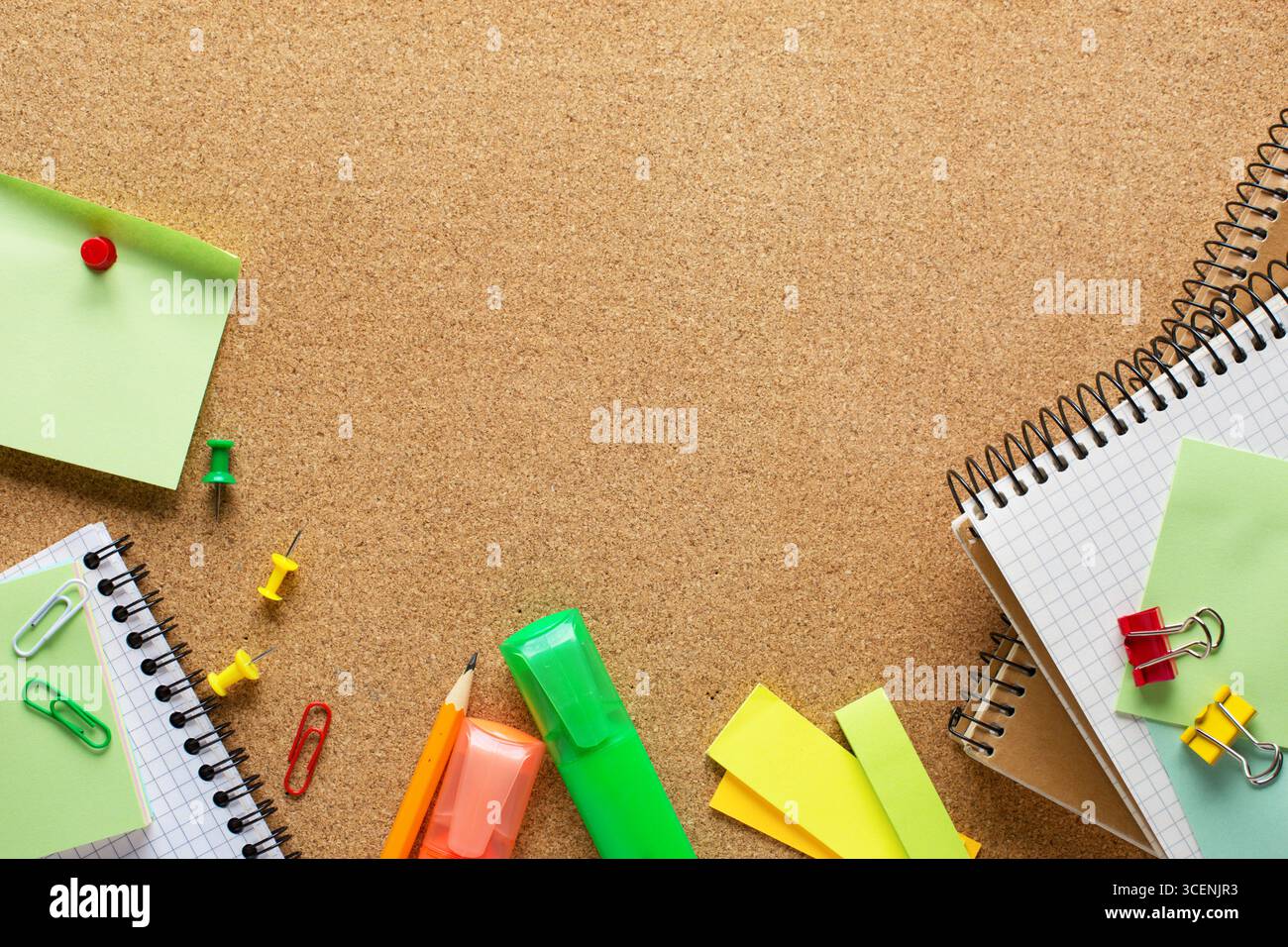 Blocs-notes, marqueurs, crayon, notes adhésives, feuilles de papier, trombones et pinces à reliure sur panneau de liège avec espace pour copier le texte. Vue de dessus de SC coloré Banque D'Images