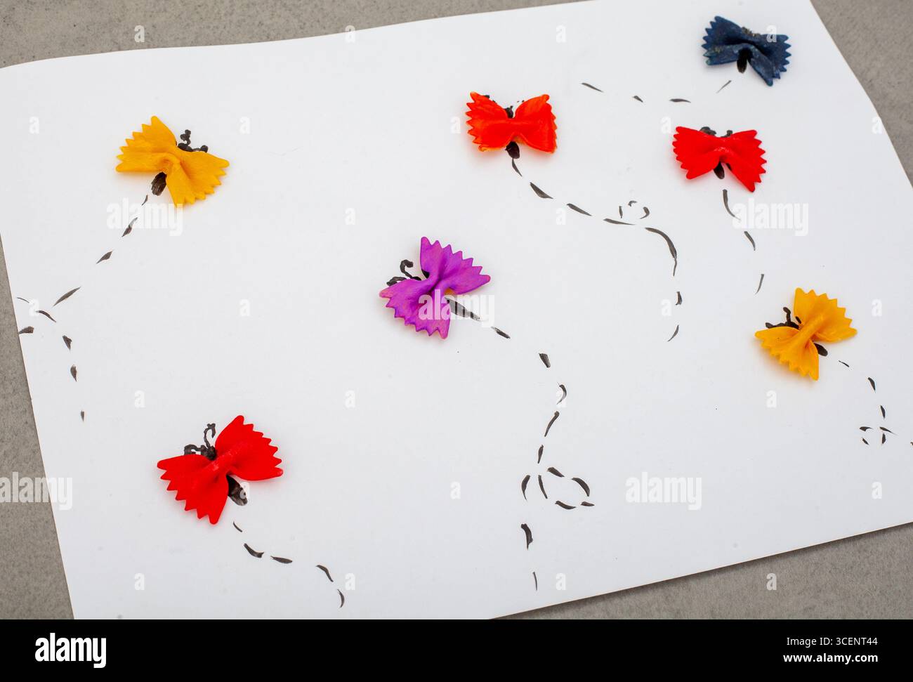 Dessin de papillons à base de pâtes alimentaires. Les papillons sont dispersés dans le papier, certains au premier plan et d'autres en arrière-plan. LO Banque D'Images