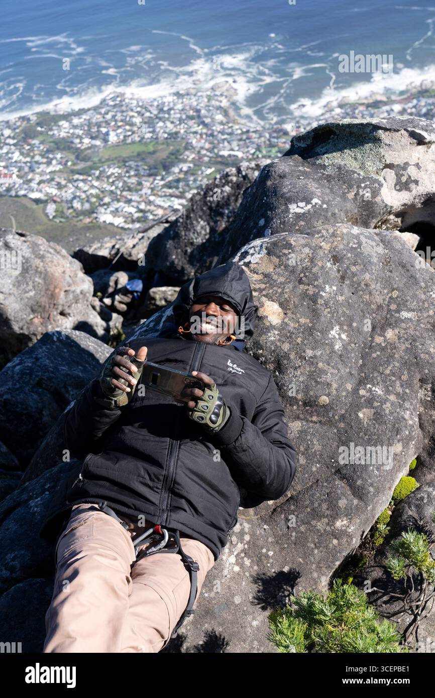 Gars en rappel allongé sur le rocher sur le sommet de la montagne de la table, Cape Town - Afrique du Sud Banque D'Images