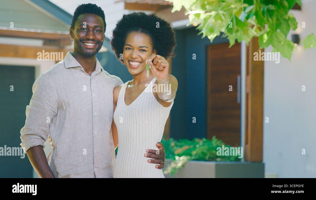 Portrait de couple à l'extérieur tenant des clés à Dream Home Banque D'Images