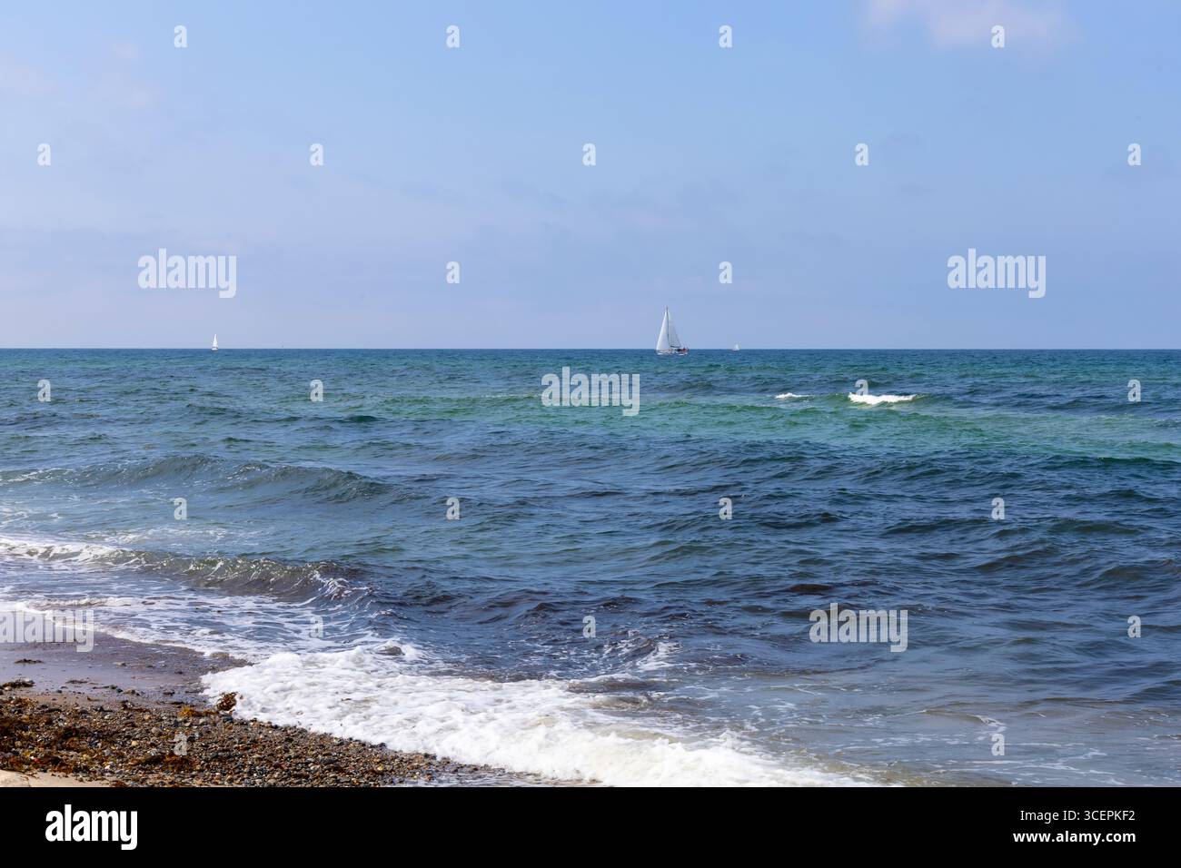 Mer bleue avec des vagues, temps clair, et un yacht loin. Photo de haute qualité Banque D'Images
