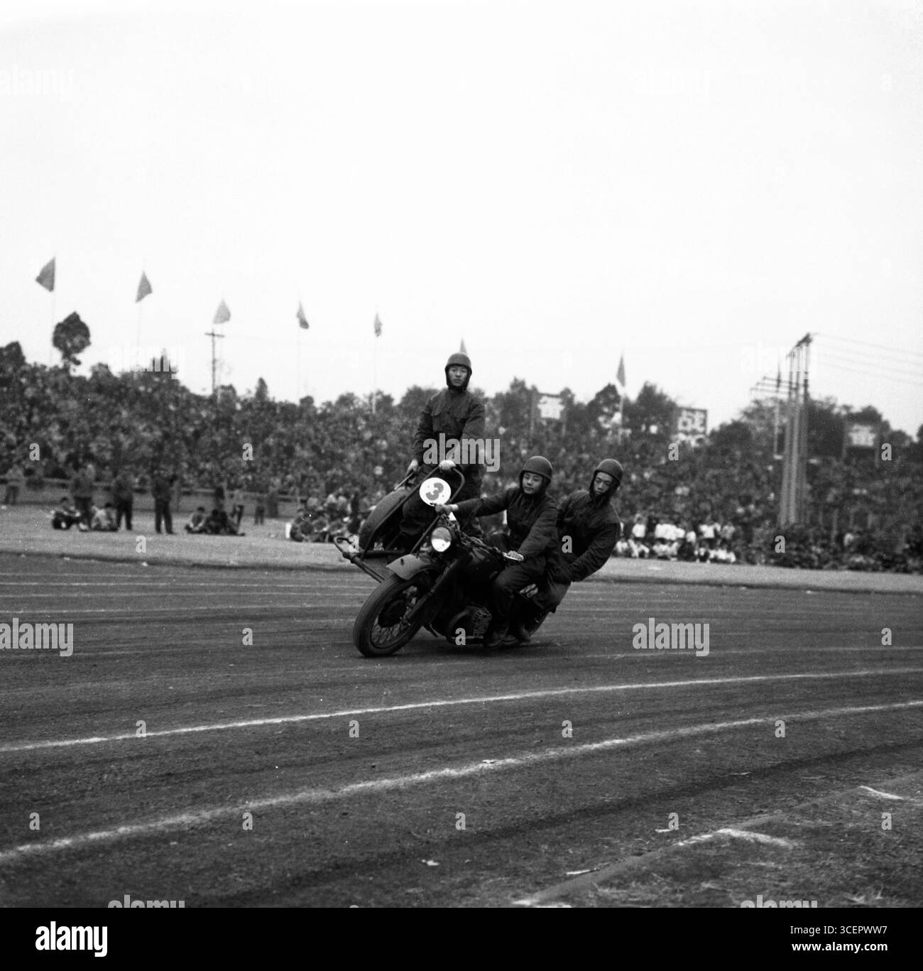 Démonstration de cascades de moto de l'armée chinoise des années 1970 - scène de foule noire et blanche Banque D'Images