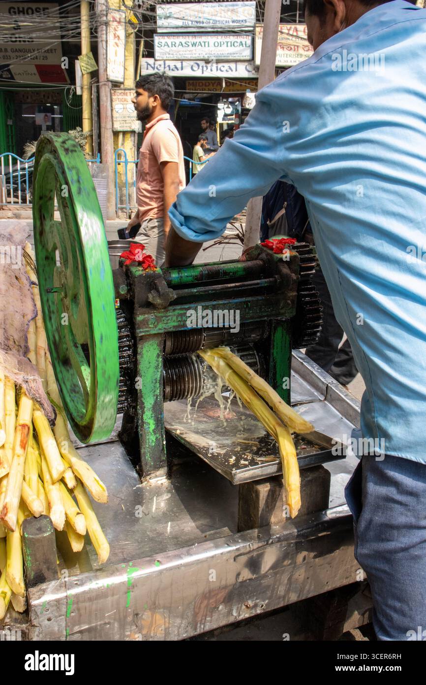 KOLKATA, BENGALE OCCIDENTAL, INDE - 19 FÉVRIER 2024 scène de rue typique dans la ville avec une vieille machine à jus de canne à sucre manuelle typique Banque D'Images