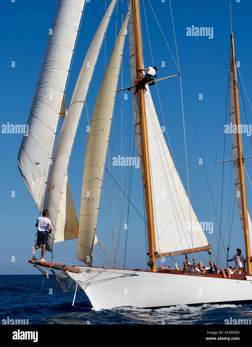 Classic Sailing Yacht voile avec équipage travaillant sur le mât dans Clear Blue Ocean Banque D'Images