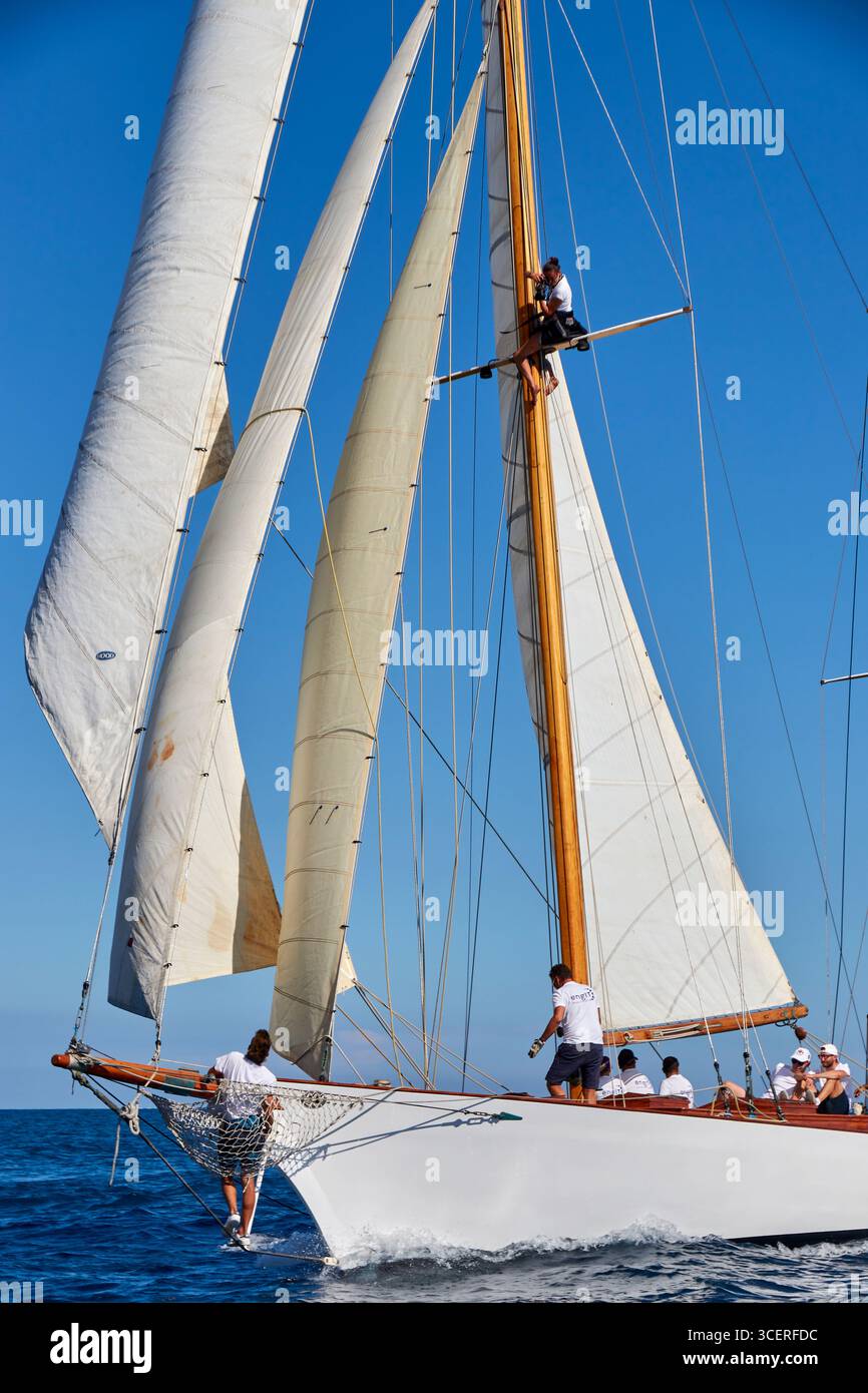 Classic Sailing Yacht voile avec équipage travaillant sur le mât dans Clear Blue Ocean Banque D'Images