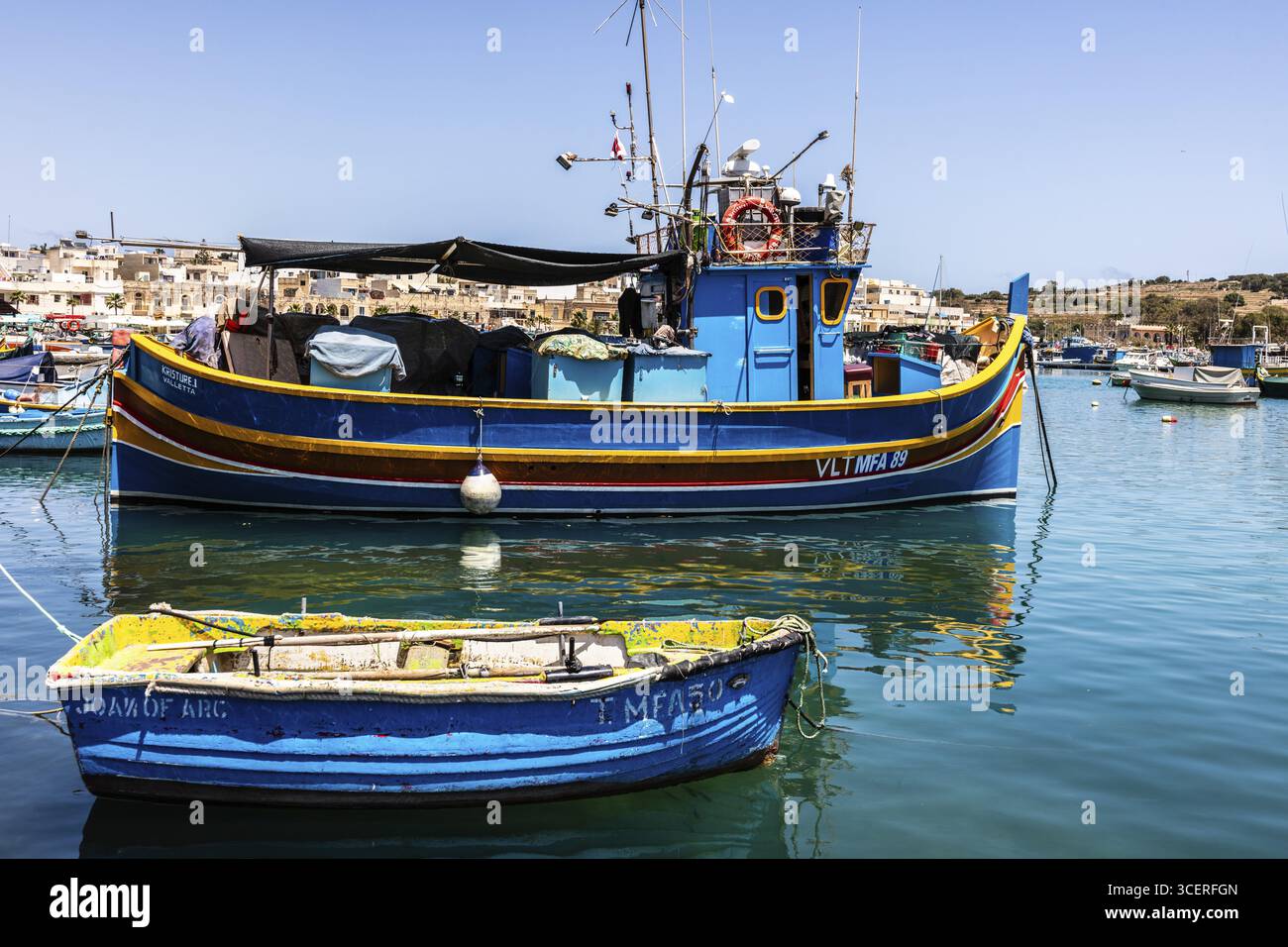 Marsaxlokk, pittoresque village de pêcheurs avec des petits bateaux Luzzu colorés avec l'œil d'Osiris sur la proue avec pour toile de fond la mer turquoise Banque D'Images