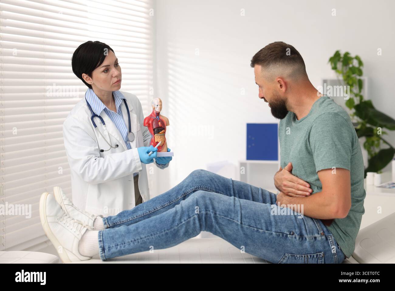 Gastro-entérologue montrant l'intestin en anatomie humaine mannequin au patient en clinique Banque D'Images