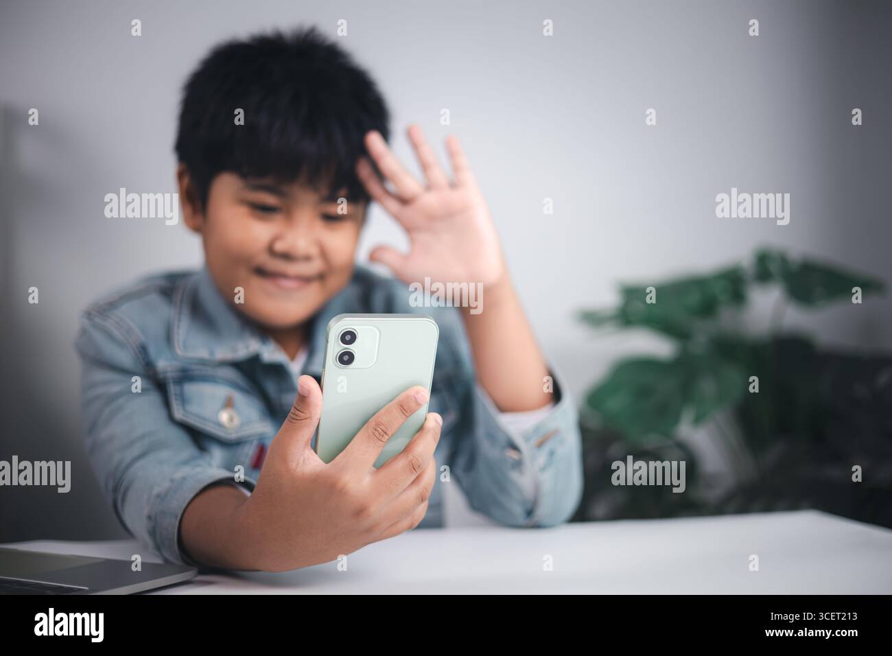 Communication numérique, technologie mobile, mode de vie des jeunes, connexion sociale et interaction en ligne moderne via des appareils. Jeune personne souriante wavi Banque D'Images