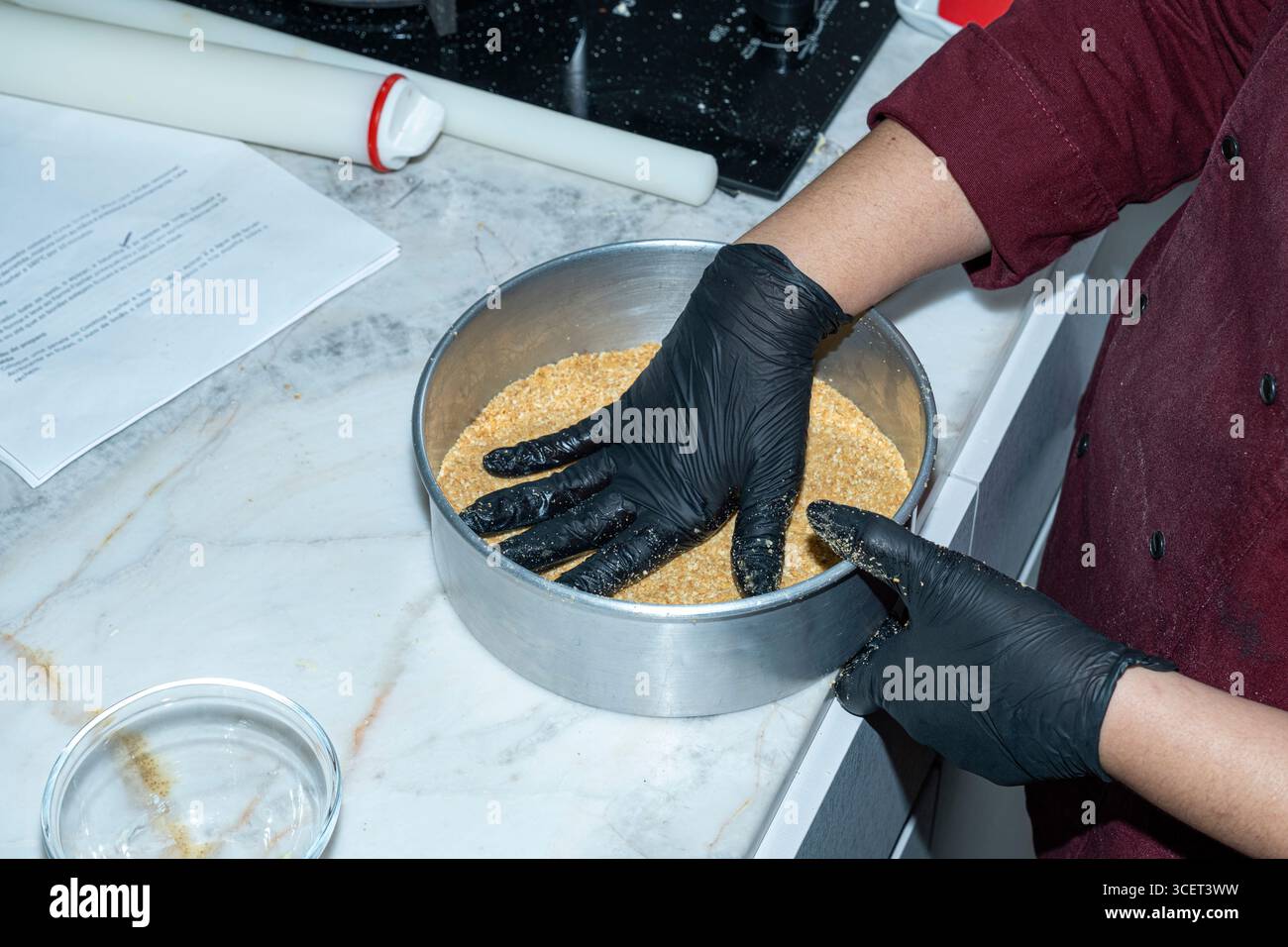 Chef façonnant la pâte dans la poêle avec ses mains. Banque D'Images