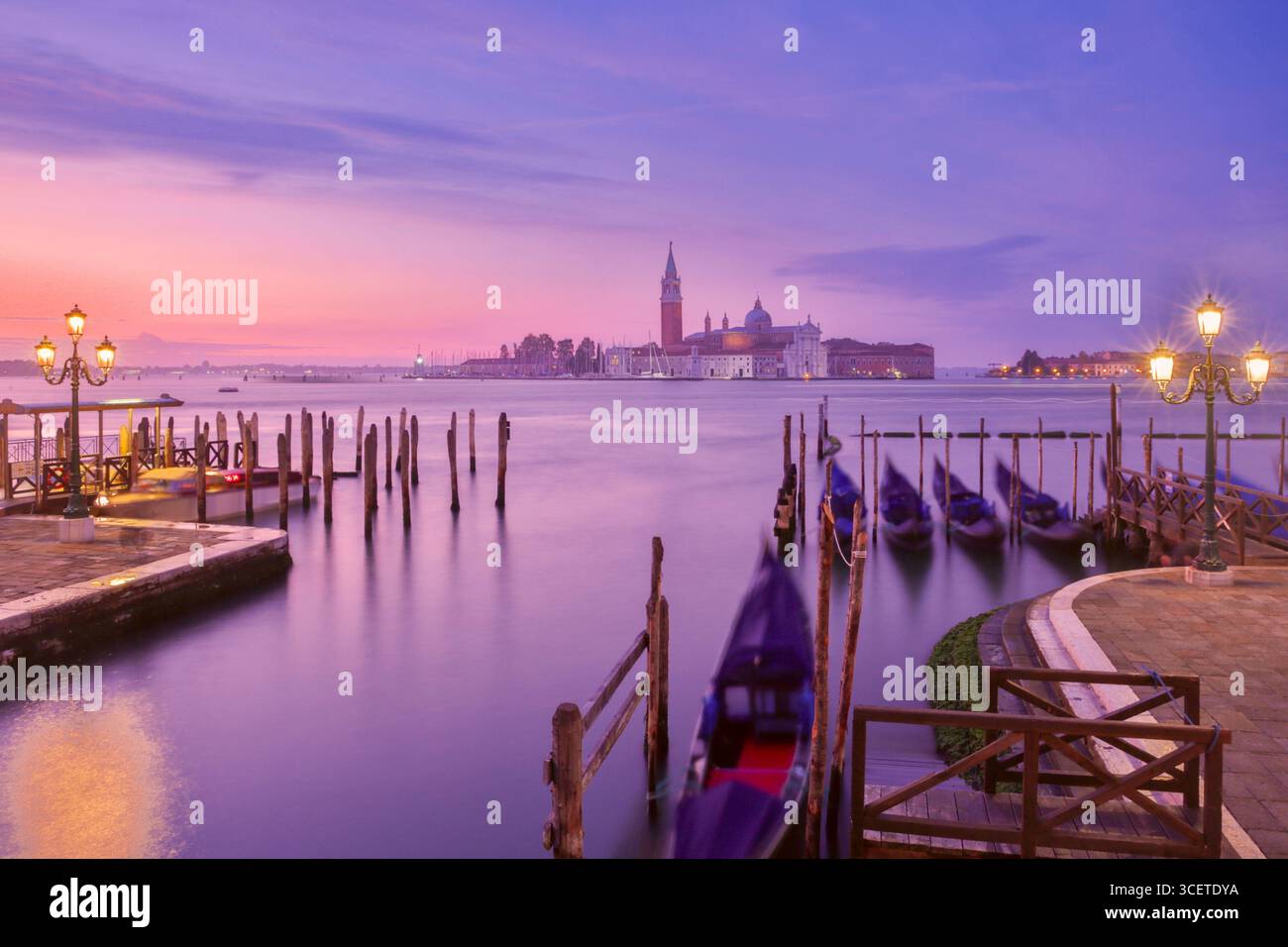 Vue sur l'île San Giorgio Maggiore et les gondoles amarrées au lever du soleil à Venise Italie Banque D'Images