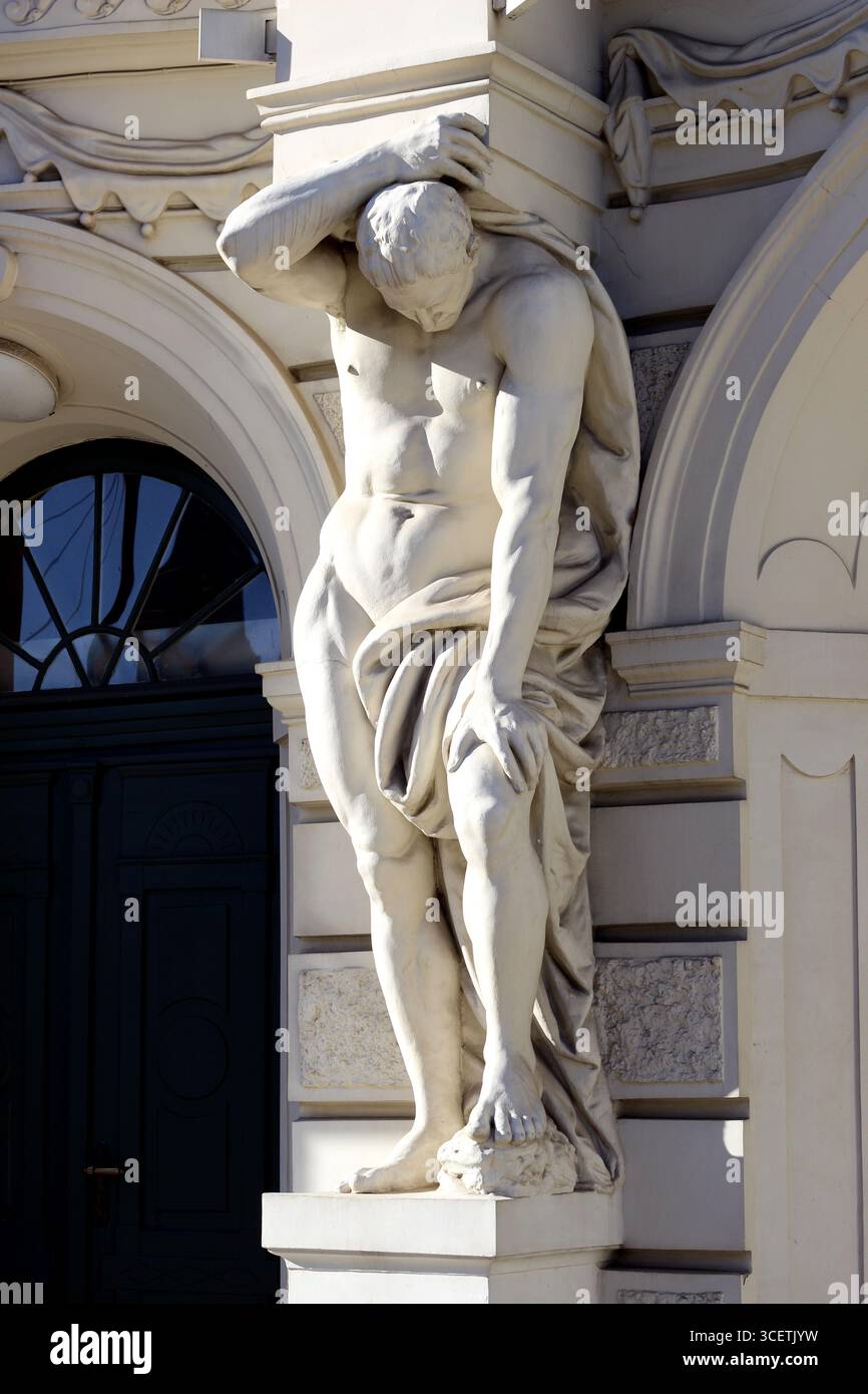Poids du monde - statue masculine néoclassique à l'entrée du Théâtre national letton, Riga Banque D'Images