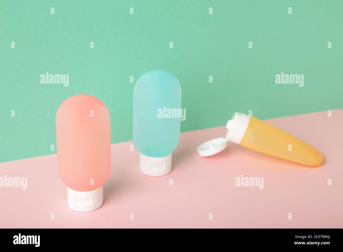 Bouteilles de voyage avec des cosmétiques de soins du corps sur fond coloré. Vue de dessus Banque D'Images