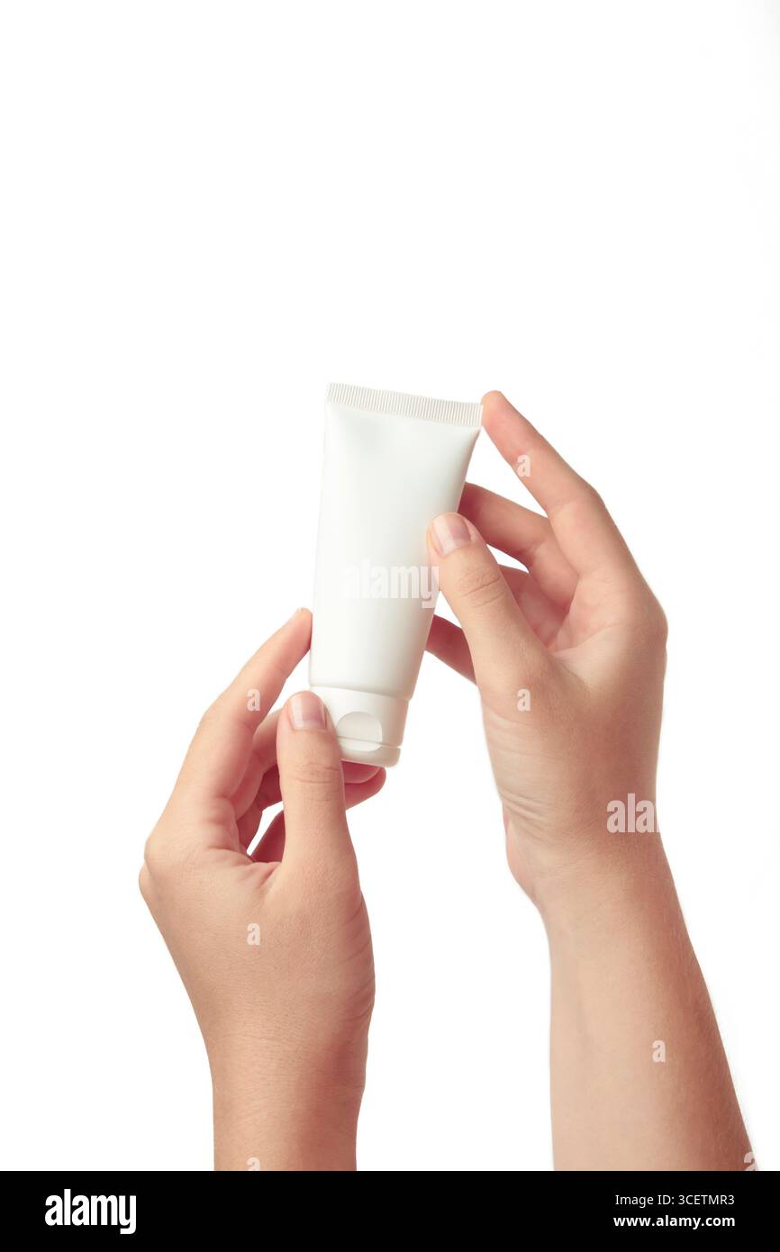 Main tenant le tube blanc blanc en plastique isolé sur fond blanc. Maquette de marquage de produit cosmétique de beauté. Banque D'Images