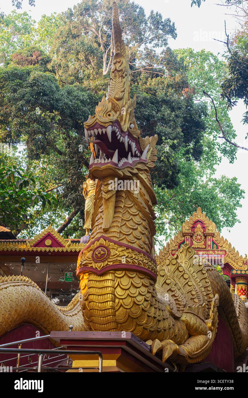 Puissante statue de dragon doré présentant des dents tranchantes et une couronne ornée à l'entrée du monastère Banque D'Images