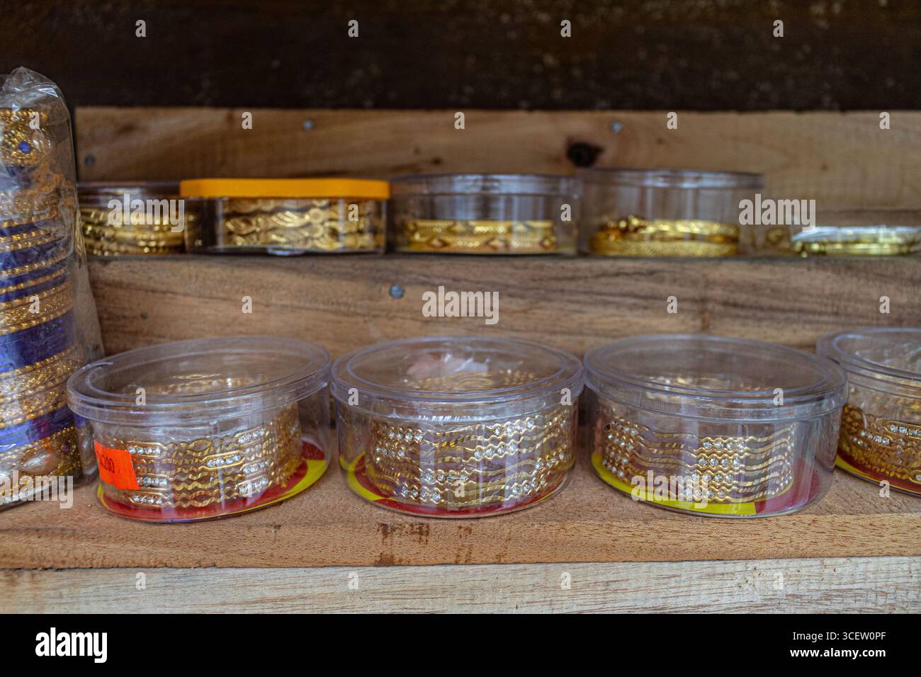 Présentoir de bijouterie avec plusieurs bracelets dorés disposés par conception à l'intérieur d'étuis de protection Banque D'Images