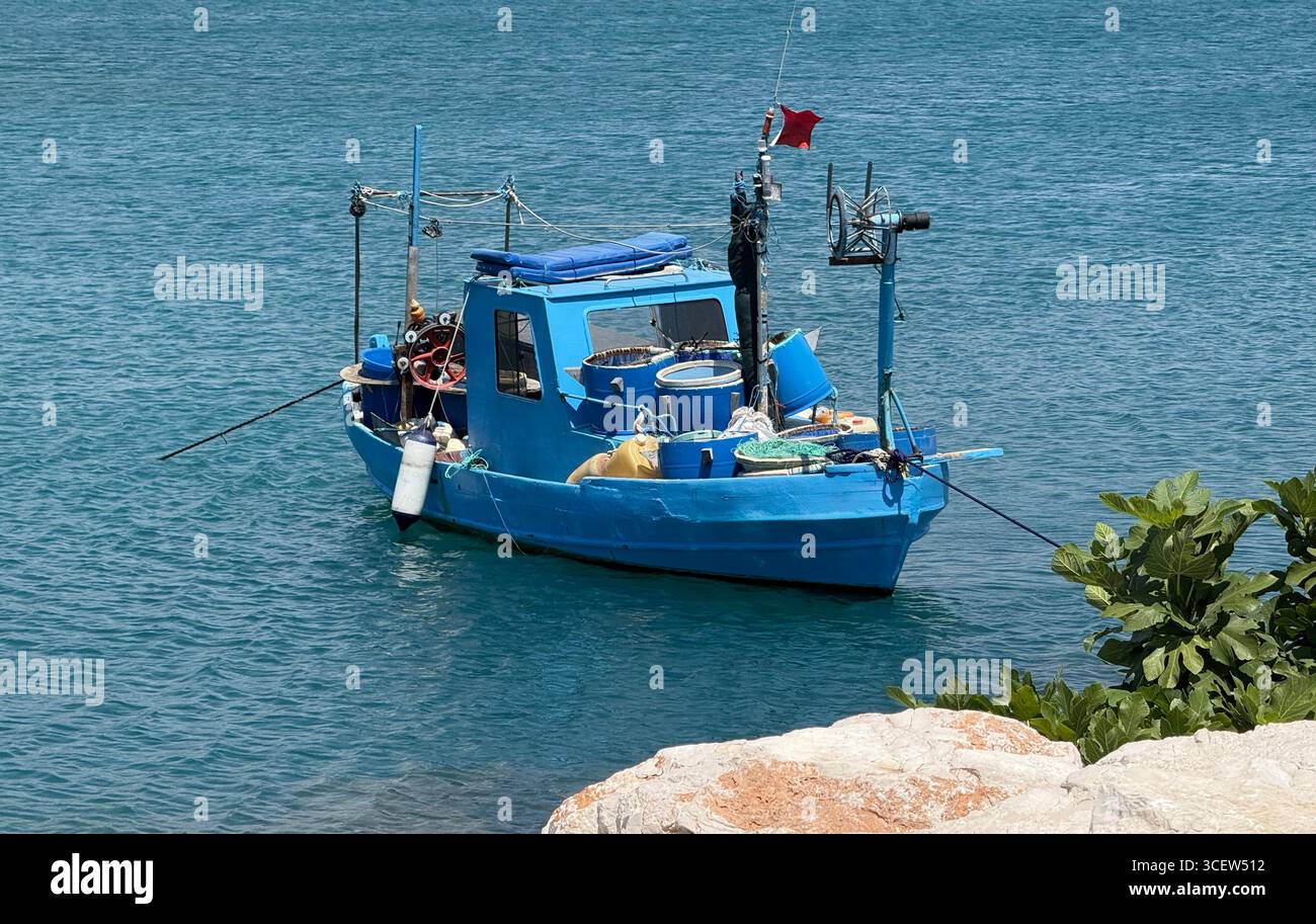 Turkiye, Antalya, Finike. Un petit bateau de pêche flotte paisiblement dans la mer sous la lumière douce du jour. Un moment tranquille de la vie sur l'eau - Image de stock capturée avec un smartphone