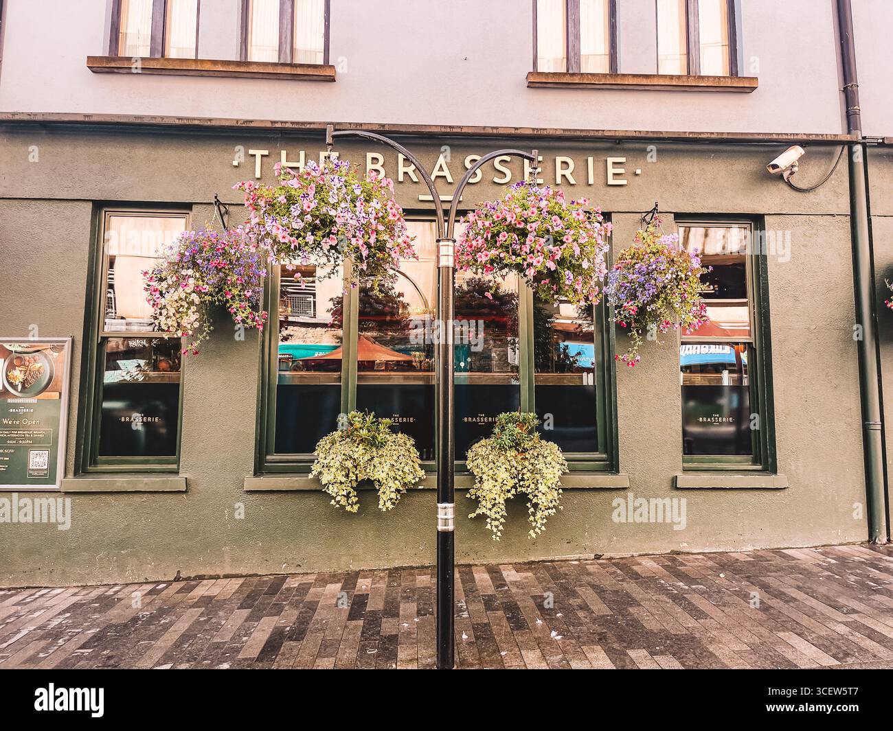 La Brasserie est un restaurant avec un extérieur vert. L'avant du restaurant a une grande fenêtre avec un panier de fleurs suspendu à it.Kilkenny irel Banque D'Images