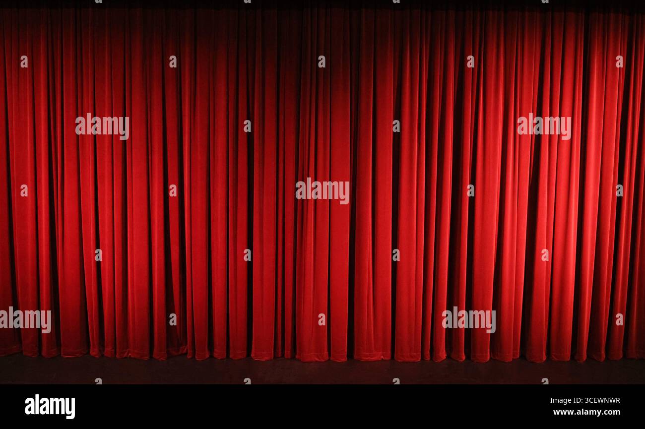 Gros plan sur les luxueux rideaux de théâtre en velours rouge-Bordeaux avec spot light. Banque D'Images