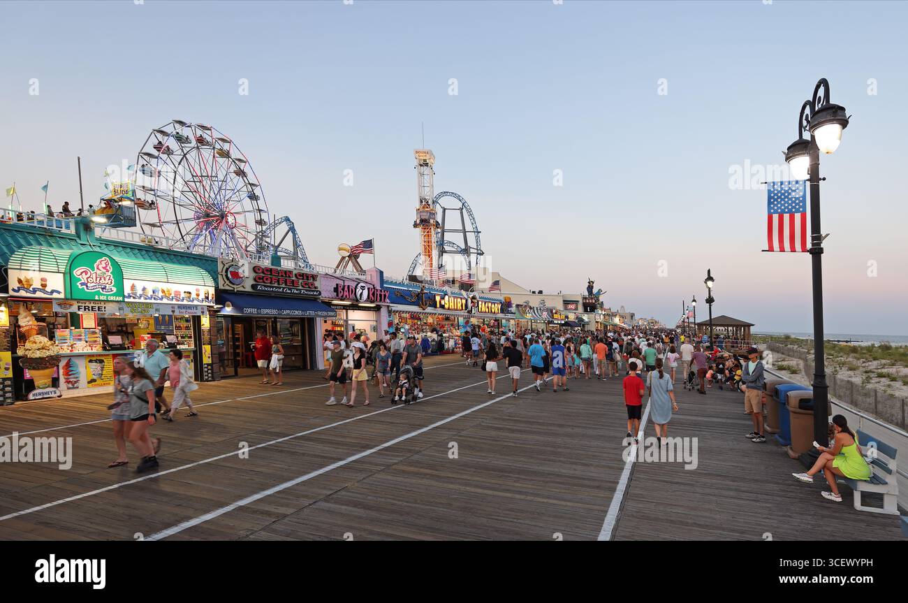 Les gens marchent le long de la célèbre promenade illuminée au crépuscule à Ocean City, New Jersey, États-Unis. Banque D'Images