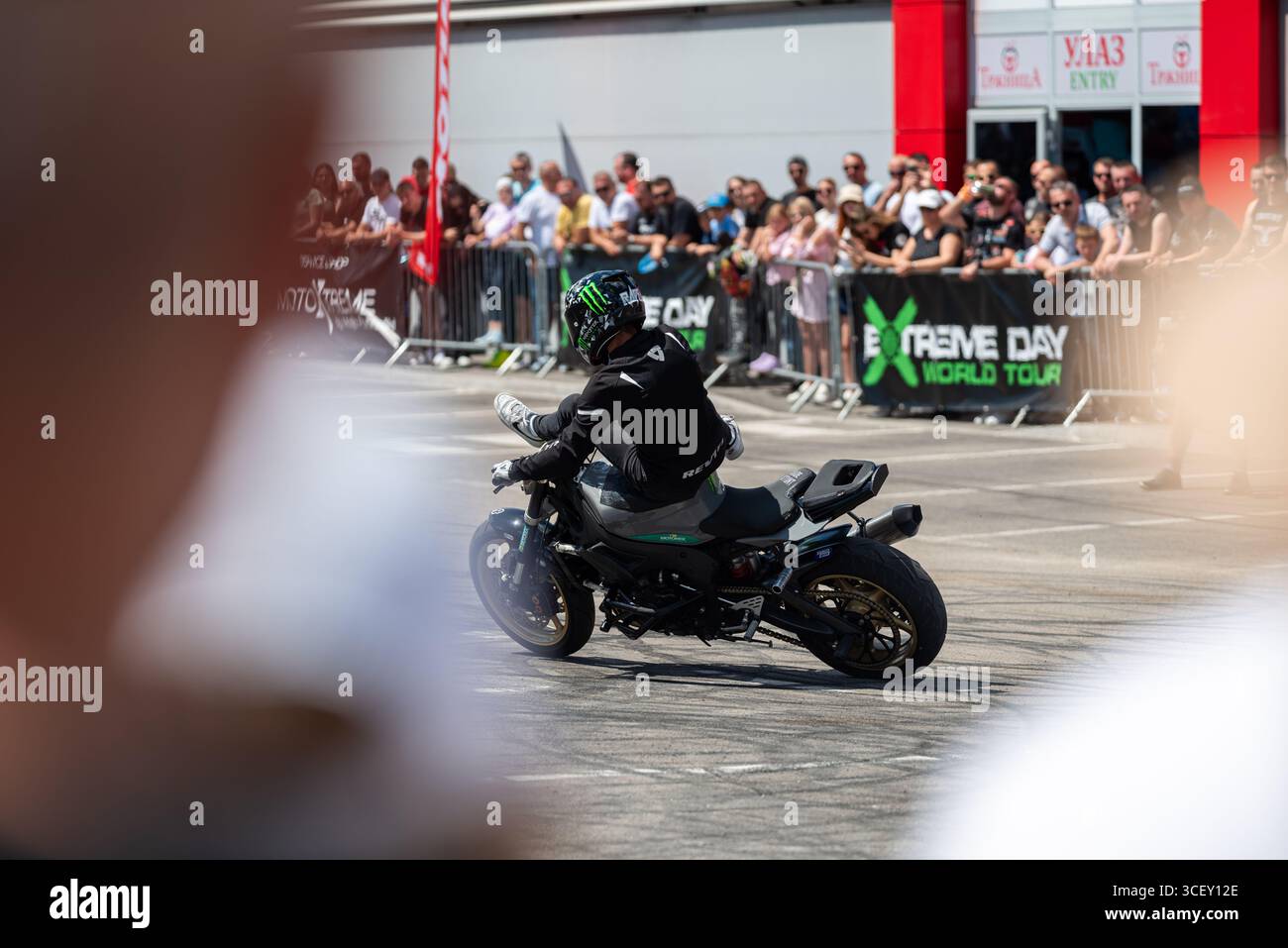 Pilote de cascadeur sur sa moto, filmé à travers le public Banque D'Images