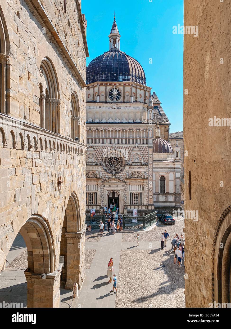 Bergame, Italie - 22 juin 2025 : les gens marchent et se rassemblent devant la Cappella Colleoni à Citta Alta, Bergame, vu des arches du Pal Banque D'Images
