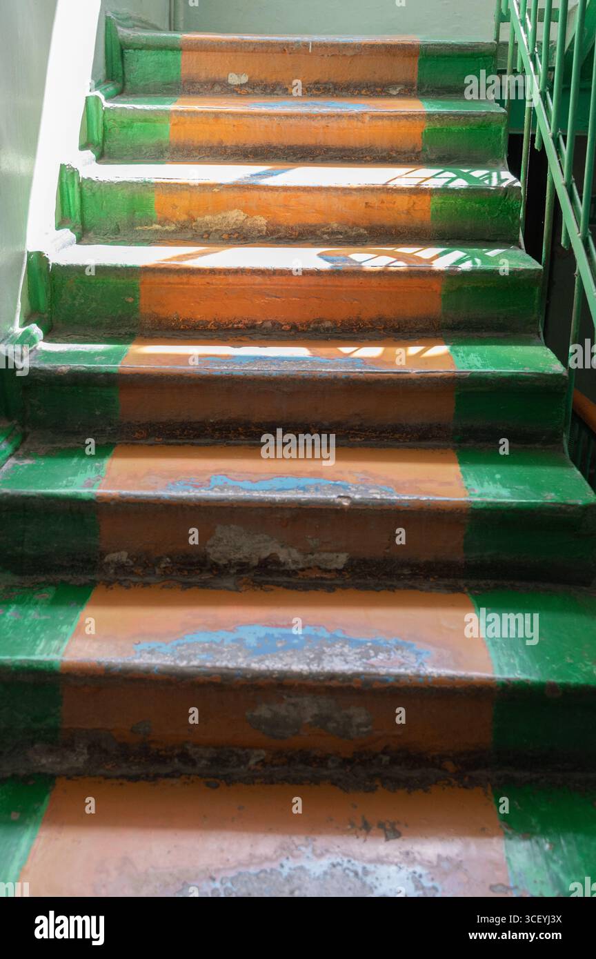 Un escalier orné de rayures vertes et oranges éclatantes affiche une tenue artistique et des signes visibles d'utilisation fréquente Banque D'Images