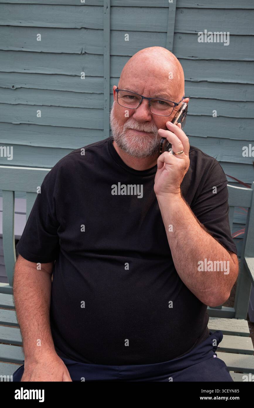 Vieil homme sur téléphone intelligent. Rester connecté avec ses amis et sa famille Banque D'Images
