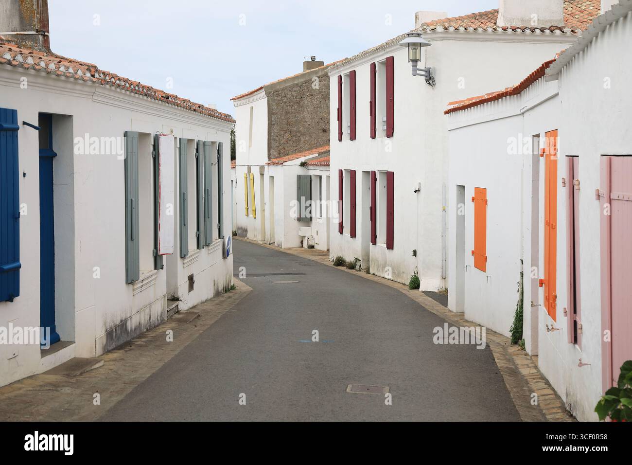 Rue typique de l'île française d'Yeu avec des maisons blanches et des volets colorés Banque D'Images Rue typique de l'île française d'Yeu avec des maisons blanches et des volets colorés Banque D'Images