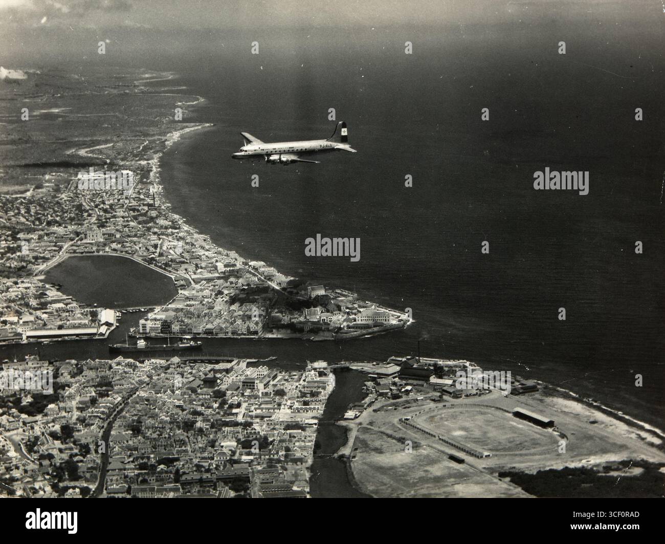 Photographie de 1946-1947 montrant un Douglas C54A Skymaster survolant Willemstad, Curaçao. L'avion, immatriculé PJ-ALO, a été utilisé pour les liaisons avec les Antilles néerlandaises pendant cette période. Banque D'Images
