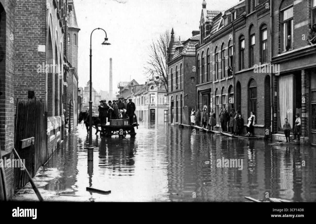 Cette photo, prise en janvier 1926, montre des crues à Valuasstraat, en regardant vers Puteanusstraat. Sur le coin gauche se trouve la tour de l'église Gereformeerde. À droite, Café Deckers est visible. Le grand bâtiment au bout de la rue est le bain sur Mgr. Nolensplein, ouvert le 1er mars 1891. En arrière-plan, on peut voir la cheminée de la centrale électrique. Banque D'Images