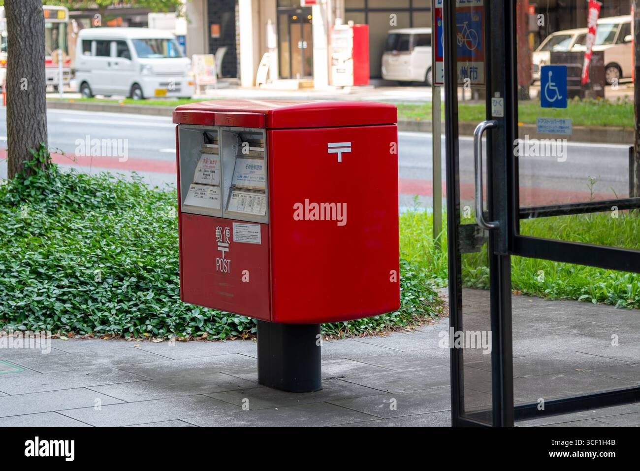 JP Post boîte aux lettres rouge sur le trottoir au Japon. Service de courrier postal Banque D'Images