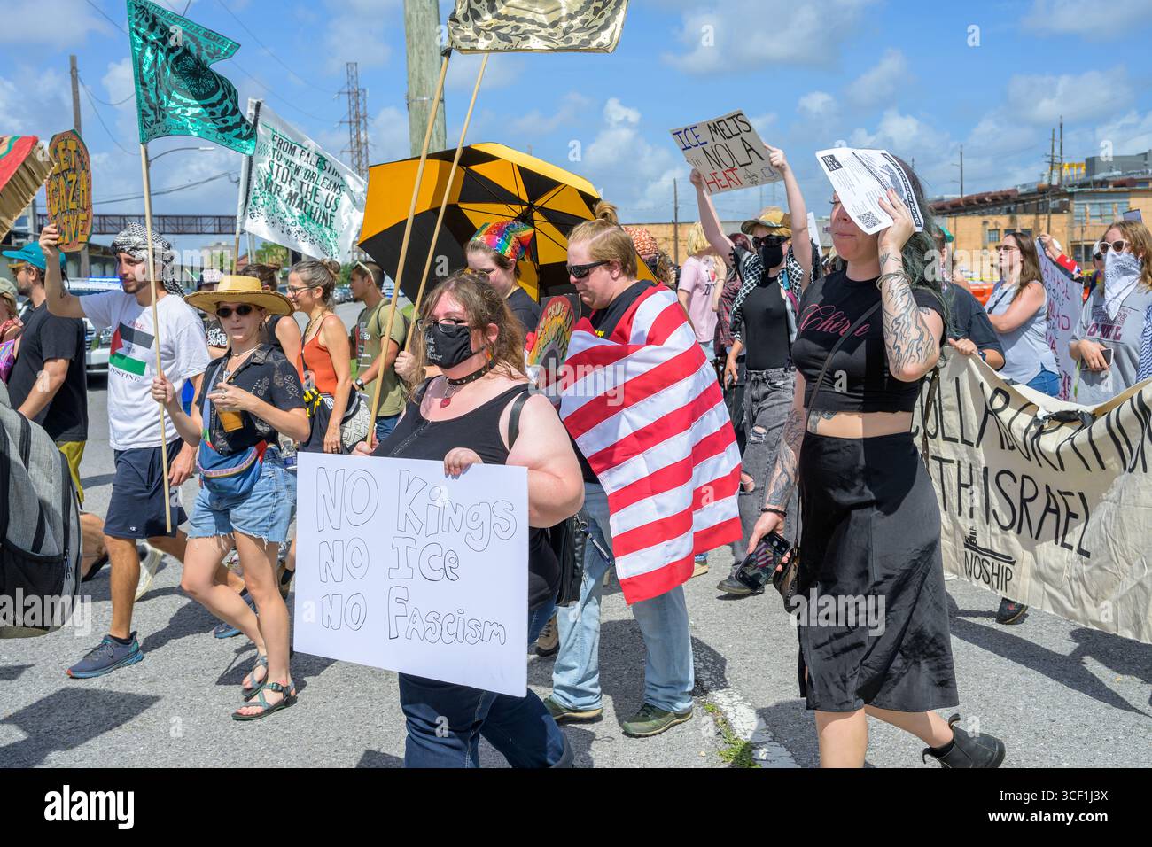 Nouvelle-Orléans, LOUISIANE, États-Unis - 14 juin 2025 : foule diversifiée de manifestants anti-Trump avec des pancartes, des parapluies, des bannières et des drapeaux défilent dans le défilé No Kings Day dans le quartier de Marigny Banque D'Images