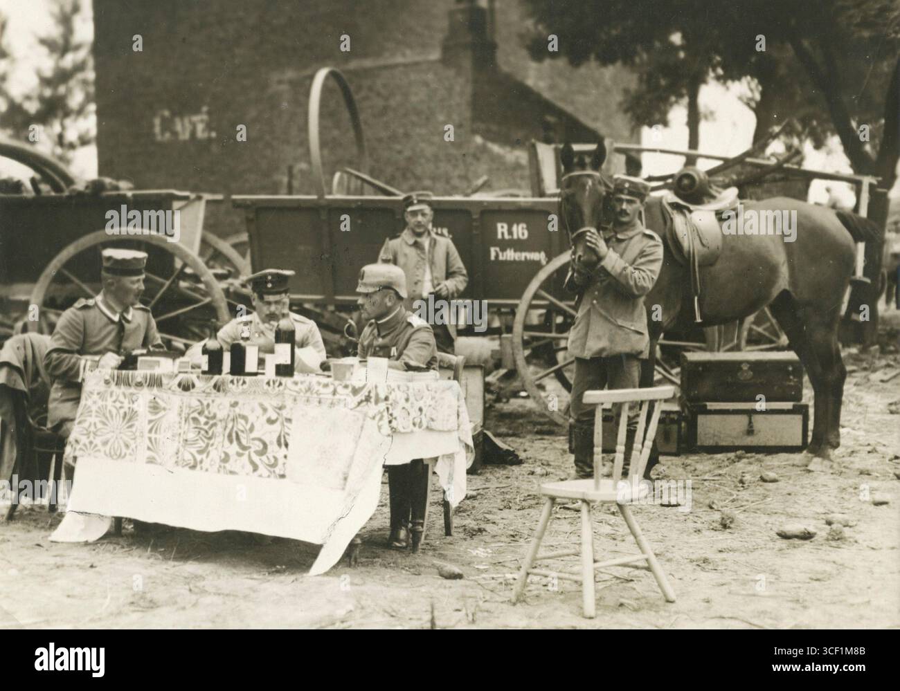 Les officiers discutent des plans de bataille sur une table avec des bouteilles de vin le 18 août 1914, en Belgique. La scène implique le régiment d'infanterie allemand Brême no 75, positionné à l'ouest de Mouland/Moelingen pendant la première Guerre mondiale Banque D'Images