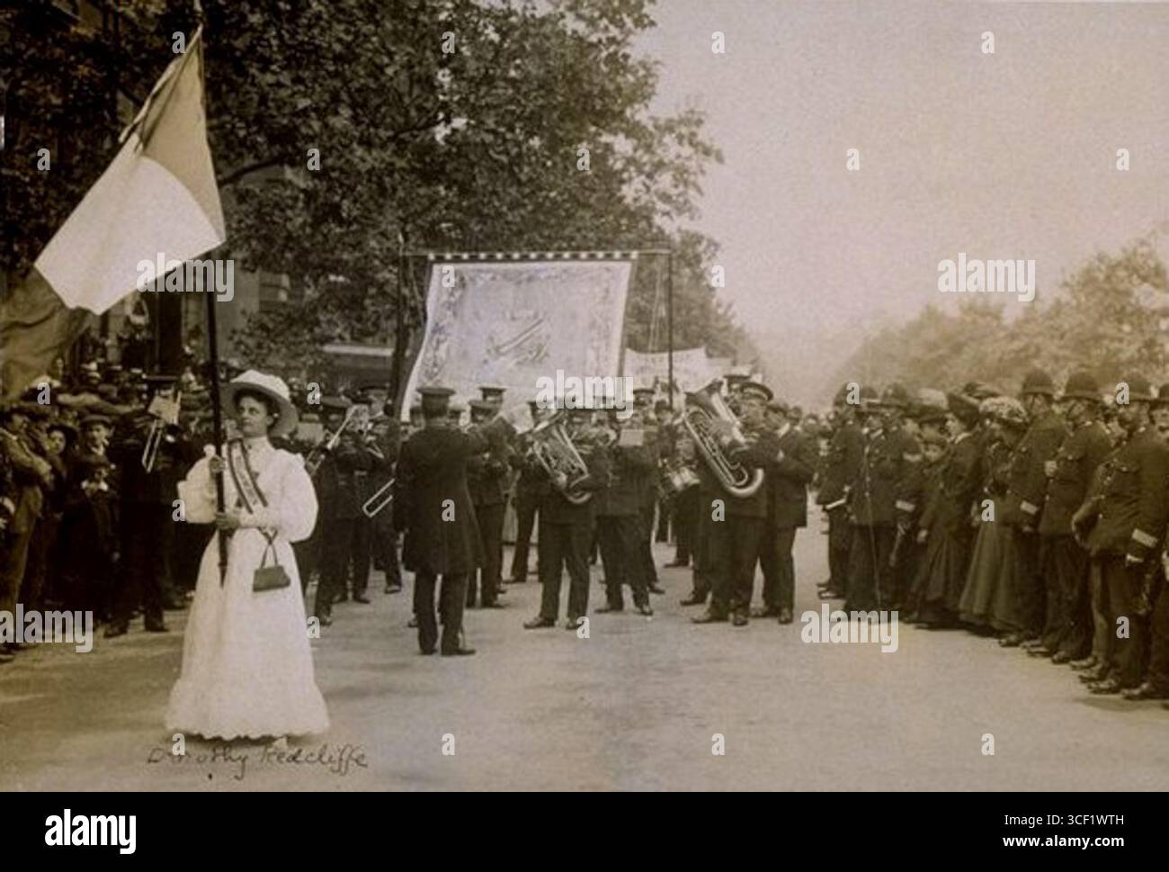 Dorothy Radcliffe est photographiée avec un drapeau violet, blanc et vert lors de la marche du dimanche féminin à Londres le 21 juin 1908. Cet événement, qui a réuni 300 000 participants, faisait partie des efforts du mouvement des suffragettes pour le droit de vote des femmes au Royaume-Uni. L'indicateur représente les couleurs suffragistes. Banque D'Images