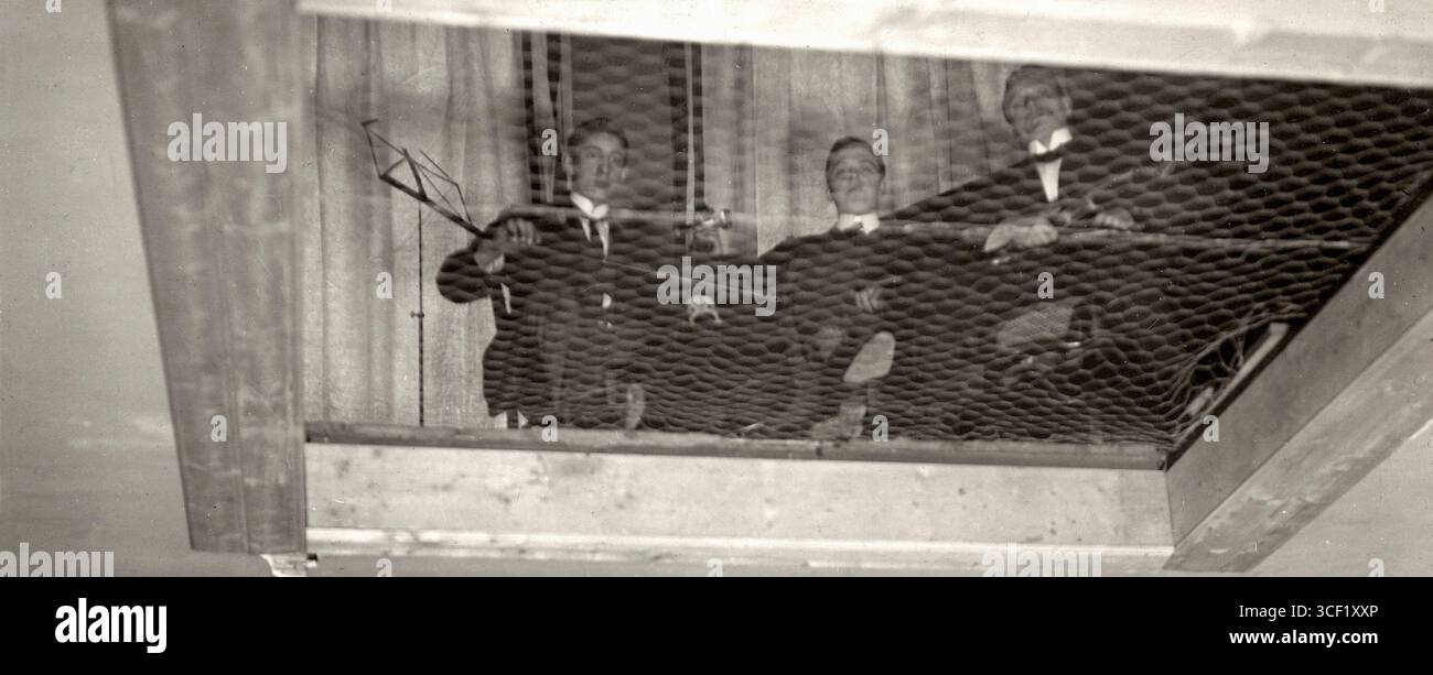 Une blague des Fools d'avril 1914 de Het Leven montre trois musiciens confinés dans une pièce avec du fil de treillis, représentés comme des victimes de la maladie du sommeil. Banque D'Images