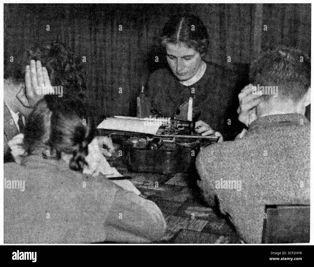 Clara Asscher-Pinkhof, l'écrivain hollandais, est montrée dans un salon bondé travaillant en 1936. La scène reflète le côté intellectuel et domestique de sa vie durant cette période. Banque D'Images