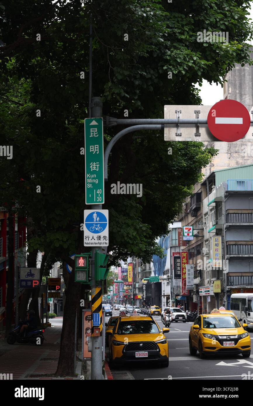 TAIPEI, TAIWAN. 1ER JUIN 2025. La rue Kun Ming à Taipei montre la vie urbaine typique avec des taxis jaunes, des panneaux chinois et un panneau de priorité piétonne Banque D'Images
