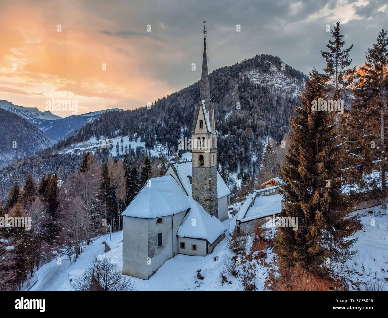 Vue aérienne de l'église de San Simon in Vallada Agordina, couverte de neige au coucher du soleil, monument historique dans la province de Belluno, région de Vénétie, Italie du Nord Banque D'Images